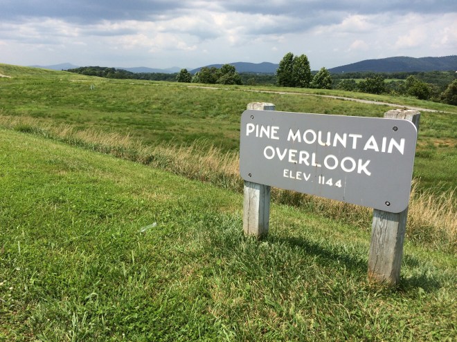 photo of a sign reading pine mountain overlook in a field.